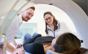 zwei Pfleger während der Behandlung im MRT