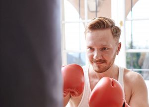 Boxer beim Training mit Sandsack und roten Handschuhen