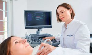 Frau Dr. Sonja Mayer mit Patient bei Ultraschalluntersuchung